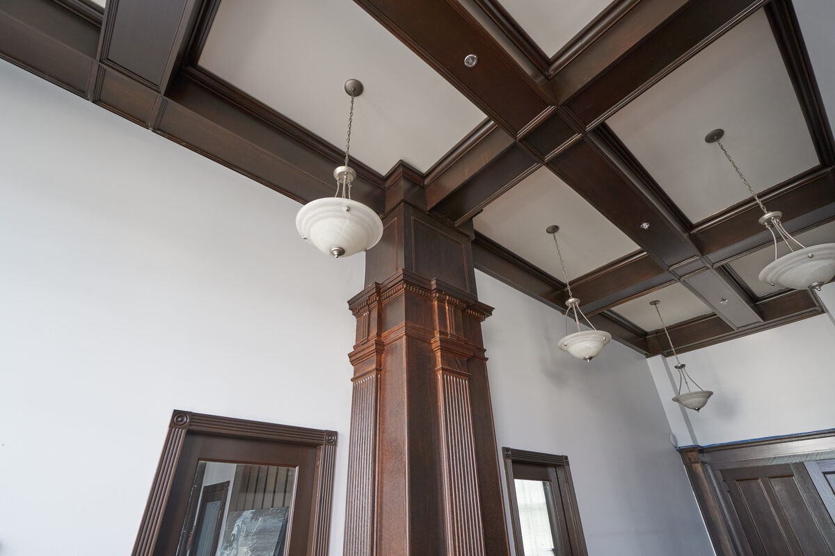 The restored lobby of Vancouver Block with coffered ceiling, columns, and period light fixtures